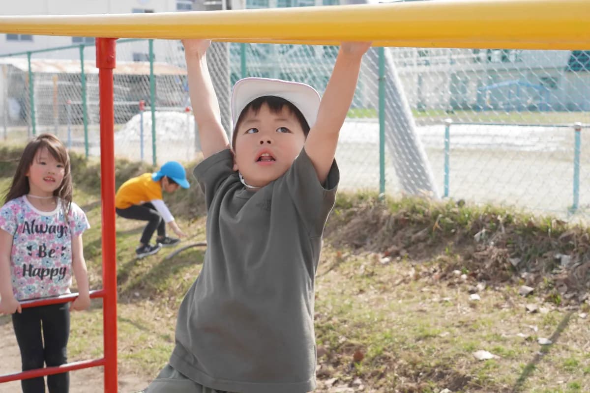 モンキーバーで遊ぶ園児